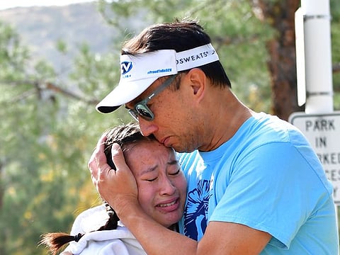 A man embraces his daughter after picking her up at Central Park, after a shooting at Saugus High School in Santa Clarita, California on November 14, 2019.