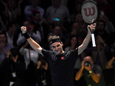 Roger Federer celebrates winning match point against Novak Djokovic.