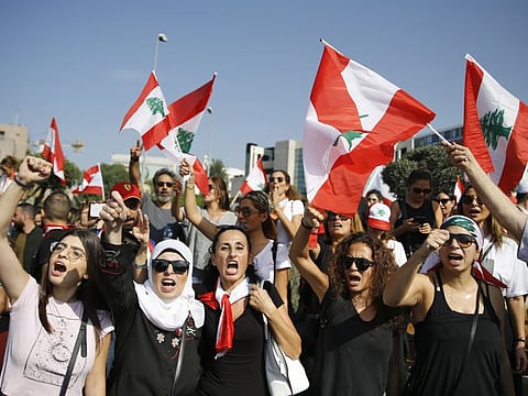 Anti-government protesters chant slogans against the Lebanese government as they block a road leading to the Presidential Palace in Baabda, east of Beirut, Lebanon, Wednesday, Nov. 13, 2019
