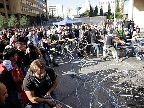 Protesters pull barbed wire during ongoing anti-government protests in Beirut, Lebanon