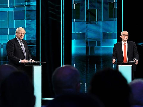 Boris Johnson, left, and Jeremy Corbyn, during their election head-to-head debate live on TV, in Manchester, England, Tuesday, Nov. 19, 2019.