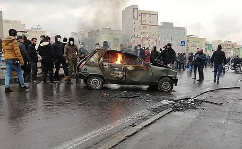 Iranian protesters gather around a burning car during a demonstration against an increase in gasoline prices in the capital Tehran, on November 16, 2019.