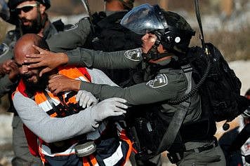 A Palestinian medic is pushed back by an Israeli soldier as he tires to help a wounded demonstrator during a protest near the Jewish colony of Beit El in the occupied West Bank, November 16, 2019