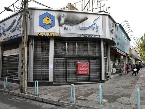 A bank that was attacked and burned during protests over rises in government-set gasoline prices, remains closed, in Tehran, Iran, Wednesday, Nov. 20, 2019. Demonstrations struck at least 100 cities and towns, spiraling into violence that saw banks, stores and police stations attacked and burned. (AP Photo/Ebrahim Noroozi)