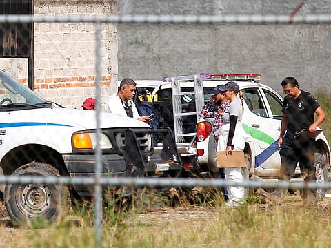 Forensic experts prepare to work in the site where several bags with human remains have been found in a common grave, in the community 'El Zapote' in Tlajomulco de Zuniga, near Guadalajara, Jalisco state, Mexico.