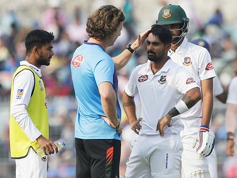 Bangladesh's team physio talks with Liton Das after he was injured by a delivery from India's Mohammed Shami during the first day of the second test match, in Kolkata, on Friday.