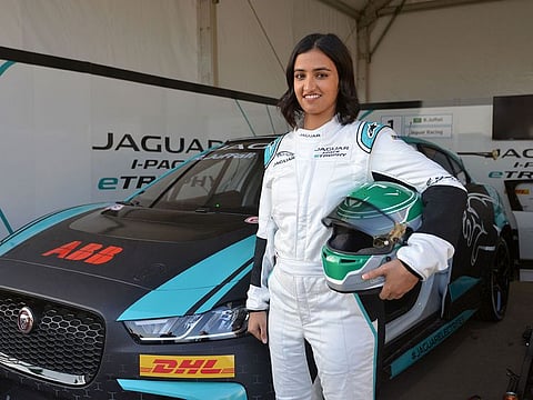 Saudi Arabia's first female race driver Reema Juffali poses in front of her car.
