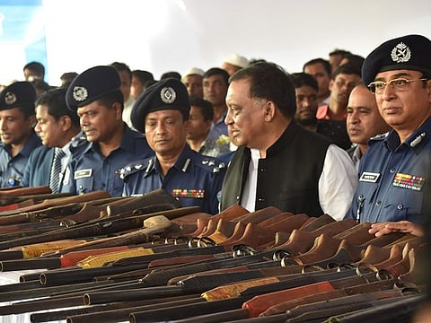 Bangladeshi pirates lay down their weapons to Bangladesh Home Minister Asaduzzaman Khan (C) as they surrender, in Cox's Bazar on November 23, 2019. Nearly 100 alleged pirates surrendered to police at a formal ceremony in southeastern Bangladesh on November 23, vowing to quit a life of ocean larceny for a quieter one ashore.