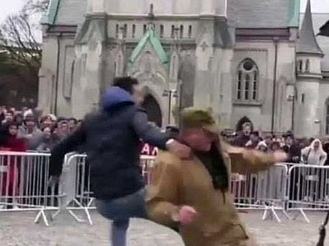 Screengrab of a video showing a young man kicking a person who tries to burn the Holy Quran during an anti-Islam rally in Norway