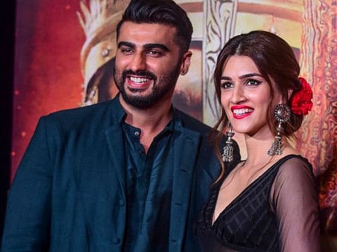 Bollywood actor Arjun Kapoor (L) and Kriti Sanon pose for photographs as they attend the song launch of their upcoming Hindi film 'Panipat' directed by Ashutosh Gowariker in Mumbai on November 23, 2019. / AFP / Sujit Jaiswal