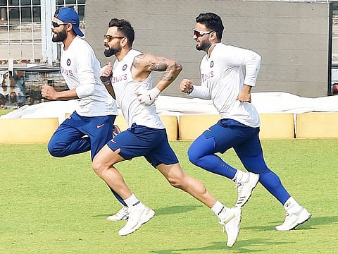 Indian captain Virat Kohli with teammates R Jadeja and Rishabh Pant warms up during a training session on the eve of the 1st pink-ball day/night cricket test match against Bangladesh at Eden Garden in Kolkata, on November 21, 2019.