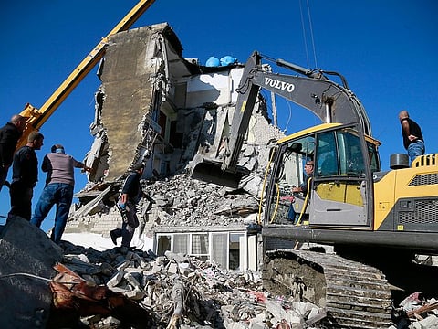 Rescuers search at a damaged building after a magnitude 6.4 earthquake in Thumane, western Albania, Tuesday, Nov. 26, 2019.