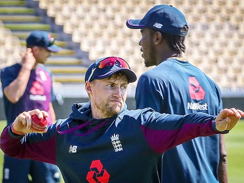 England's Jofra Archer (R) walks past team captain Joe Root (C) as he throws the ball during a team training session ahead of the second cricket Test against New Zealand at Seddon Park in Hamilton, on November 27, 2019.