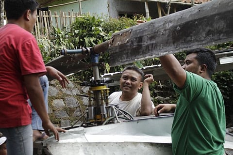 Jujun Junaedi (C) working on his homemade helicopter in his backyard in Sukabumi.