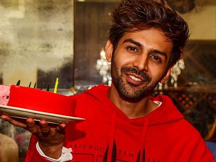 Kartik Aaryan holds a cake as he poses for photographs during his 29th birthday celebrations with media in Mumbai on November 22, 2019.
