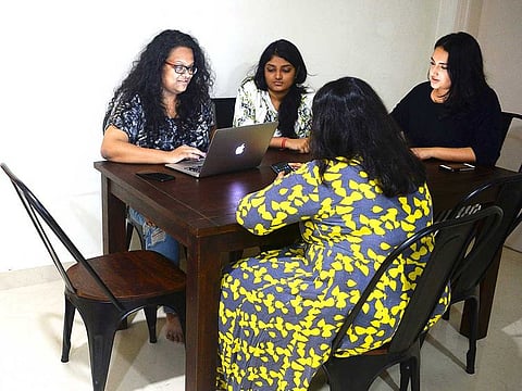 Vandita Morarka, 25, interacts with her colleagues as they sit around rented furnitures, in Mumbai.