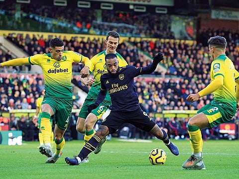 Arsenal's French striker Alexandre Lacazette (C) is surrounded by Norwich defenders.