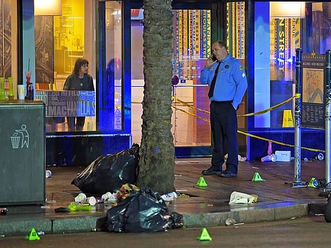 A woman looks out from inside a McDonald's fast food restaurant as New Orleans police investigate the scene of a shooting Sunday, Dec. 1, 2019, on the edge of the city's famed French Quarter.