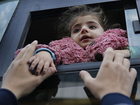 A Syrian refugee says goodbye to a relative through a bus window that will take her home to Syria, in Beirut, Lebanon, Tuesday, Dec. 3, 2019.