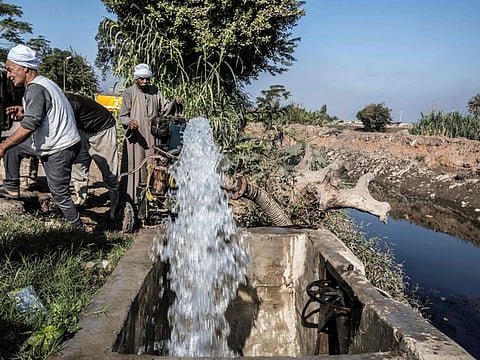 Egyptian farmer Mohamed Omar (L), 65, and other farmers supply their farmland with water from a canal, fed by the Nile river, in the village of Baharmis on the outskirts of Egypt's Giza province, northwest of the capital Cairo, on December 1, 2019.