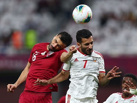 UAE's prolific striker Ali Mabkhout (No.7) being challenged by a Qatari player during their Gulf Cup match on Monday.