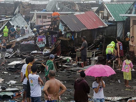 Residents stand among their damaged houses after Typhoon Kammuri hit Legazpi City, Albay, Philippines.