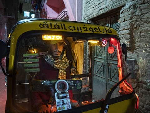 In this Nov. 19, 2019 photo, a driver maneuvers his tuk-tuk in a narrow alleyway of a slum in Cairo, Egypt.