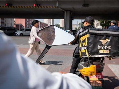 Zhang Pei rides his electric bike on his way to pick up orders in Beijing.