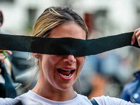 Colombian journalists take part in a choreographed performance originated in Chile, and inspired by the Chilean feminist group Las Tesis, against femicide, gender violence and patriarchy in Bogota on December 5, 2019.