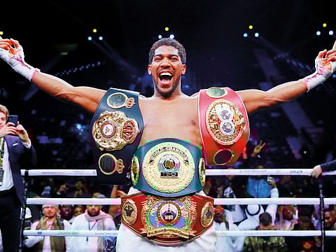 British heavyweight champion Anthony Joshua poses with the three belts after his championship fight win against Andy Ruiz in Saudi Arabia on Saturday night..