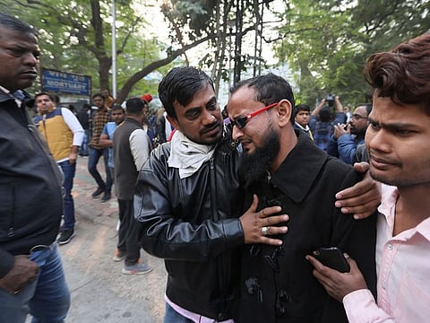 Mohammad Nazir Alam, second right, breaks down after identifying bodies of 6 people from his village who died in a fire, outside a mortuary in New Delhi.