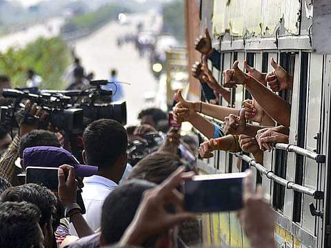 Commuters travelling on the bridge under which a veterinary doctor was raped and killed , display thumbs up sign commending the Hyderabad Police for its action against the four accused.