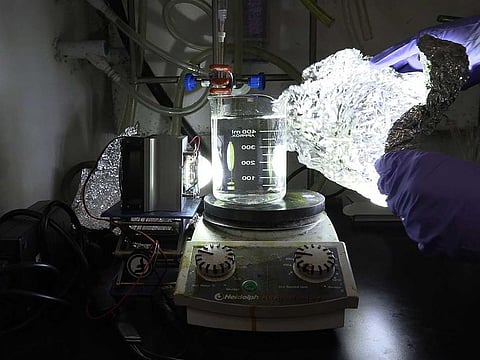 A researcher from the city's Nanyang Technological University, mixes plastic with chemicals to form a solution, which could then be broken down by artificial sunlight, in Singapore