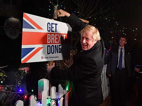 Britain's Prime Minister and Conservative party leader Boris Johnson poses with a sledgehammer, after hammering a "Get Brexit Done" sign into the garden of a supporter, in South Benfleet, Britain December 11, 2019