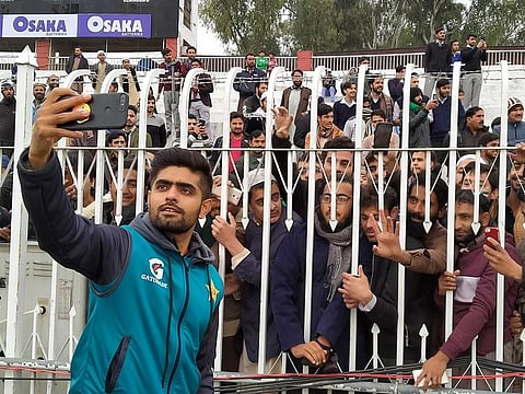 Pakistan's Babar Azam takes selfies with the fans during the rain on day 3 of the first Test.