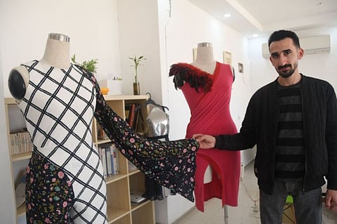 Hussam Omari displays his vintage dresses made from recycled materials.