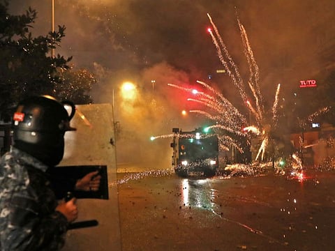 Supporters of Lebanon's Shiite Hezbollah and Amal groups hurl fireworks at security forces on December 17.