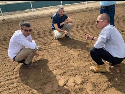 Mohammad Al Shehhi and track experts discussing the racing surface at Jebel Ali Racecourse.