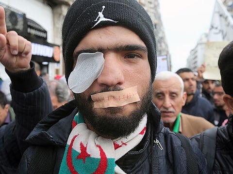 A demonstrator has his eye and mouth covered with a patch during a protest to reject the presidential election results in Algiers, Algeria December 17, 2019.