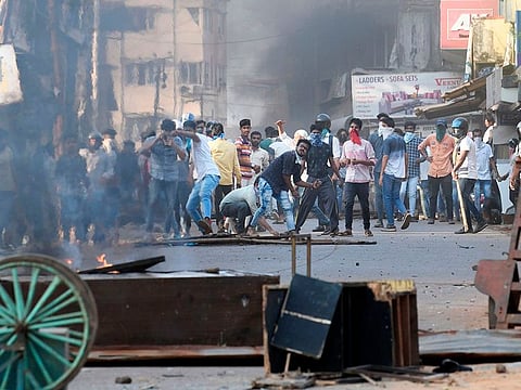 Protesters throw stones toward police during demonstrations against India's new citizenship law in Mangalore on December 19, 2019.