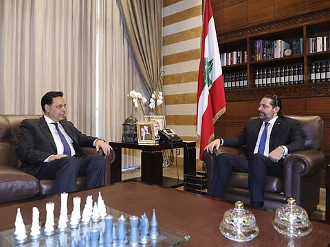 In this photo released by Lebanon's official government photographer Dalati Nohra, Lebanese Prime Minister-designate Hassan Diab, left, meets with outgoing Prime Minister Saad Hariri, in Beirut, Lebanon, Friday, Dec. 20, 2019.