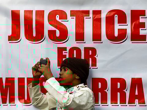 A boy films the supporters of Pervez Musharraf, after a Pakistani court sentenced the former military ruler to death on charges of high treason and subverting the constitution, during a protest in Karachi on December 20, 2019.