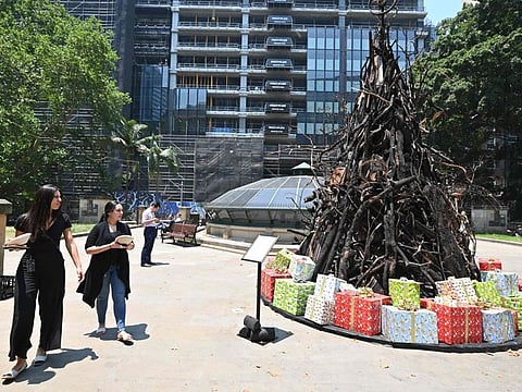 People look at an installation dubbed 'the Burnt Christmas Tree' to support the Australian Red Cross Disaster Relief and Recovery Fund in Sydney on December 18, 2019 in the wake of the bushfire situation across the state. Australians on the east coast were bracing for a "new threat" as a heatwave accompanied by turbulent winds bears down on more than 100 bushfires in the region. - RESTRICTED TO EDITORIAL USE - MANDATORY MENTION OF THE ARTIST UPON PUBLICATION - TO ILLUSTRATE THE EVENT AS SPECIFIED IN THE CAPTION
/ AFP / PETER PARKS / RESTRICTED TO EDITORIAL USE - MANDATORY MENTION OF THE ARTIST UPON PUBLICATION - TO ILLUSTRATE THE EVENT AS SPECIFIED IN THE CAPTION