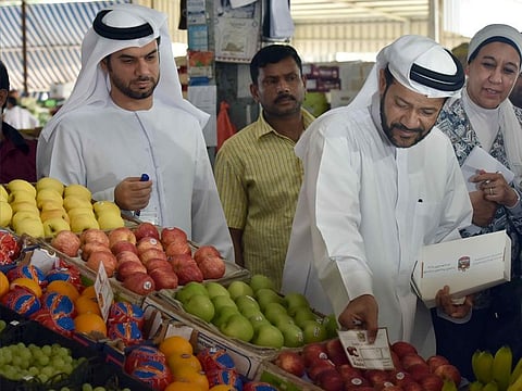 File photo: Dr. Hashim Saeed Al Nuaimi, Director of the Ministry of Economy’s Consumer Protection Department (right) introducing price tags at the fruit and vegetable market in Abu Dhabi during an inspection tour at the market. Picture used for illustrative purposes only.