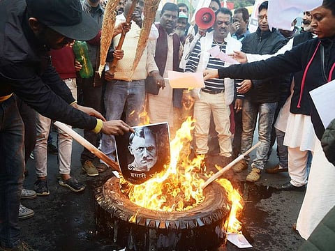 Protesters burn a poster comparing Indian Prime Minister Narendra Modi to German chancellor and Nazi Party leader Adolf Hitler at a demonstration against India's new citizenship law in Siliguri on December 18, 2019.