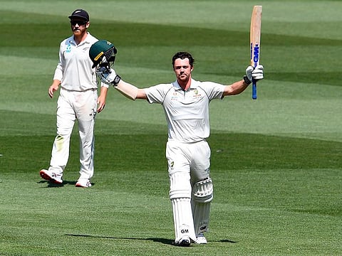 Australian batsman Travis Head celebrates scoring his century as New Zealand captain Kane Williamson (L) looks on during the second day of the second cricket Test match at the MCG in Melbourne on December 27, 2019.