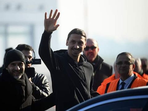 Zlatan Ibrahimovic waves to fans on his arrival in Milan.