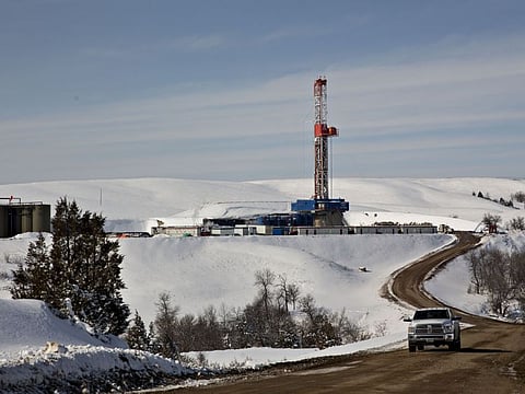 File photo: A vehicle travels on a lease road as a drill rig operates in in the Bakken Formation in the background, in Williston, North Dakota, U.S., on Thursday, March 8, 2018.