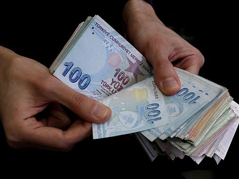 File photo: A merchant counts Turkish lira banknotes at the Grand Bazaar in Istanbul, Turkey.