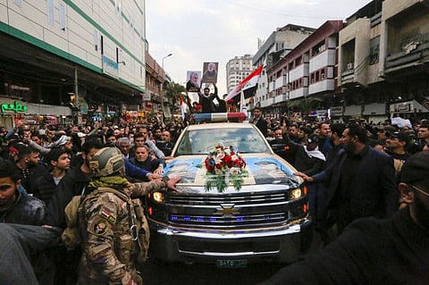 Iraqis mourn over a coffin during the funeral procession of Iraqi paramilitary chief Abu Mahdi al-Muhandis and Iranian military commander Qasem Soleimani, and eight others, in Kadhimiya, a Shiite pilgrimage district of Baghdad, on January 4, 2020. Thousands of Iraqis chanting "Death to America" joined the funeral procession Saturday for Iranian commander Qassem Soleimani and Iraqi paramilitary chief Abu Mahdi al-Muhandis, both killed in a US air strike. The cortege set off around Kadhimiya, a Shiite pilgrimage district of Baghdad, before heading to the Green Zone government and diplomatic district where a state funeral was to be held attended by top dignitaries. In all, 10 people -- five Iraqis and five Iranians -- were killed in Friday morning's US strike on their motorcade just outside Baghdad airport. / AFP / SABAH ARAR